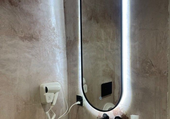 A bathroom with a mirror and a hair dryer.
