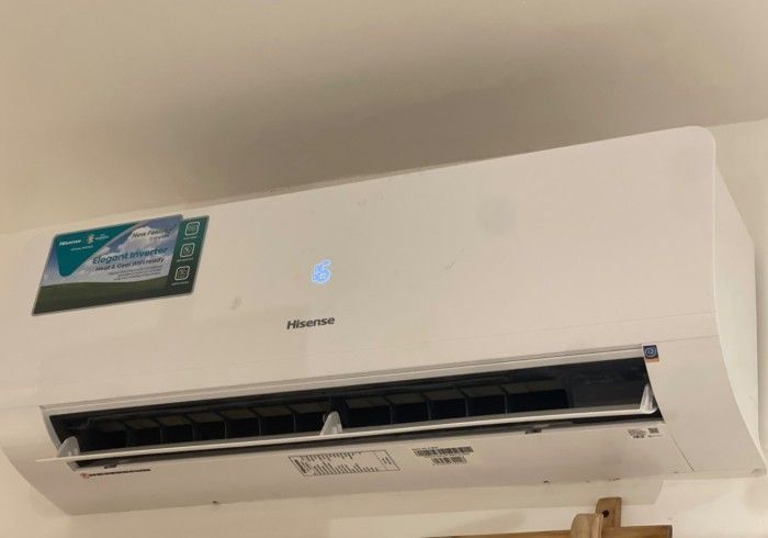 A white air conditioner is hanging from the ceiling in a room.