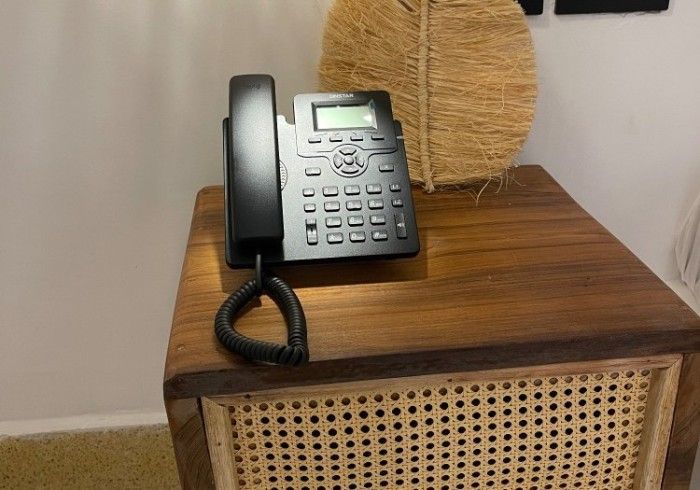 A telephone is sitting on top of a wooden table.