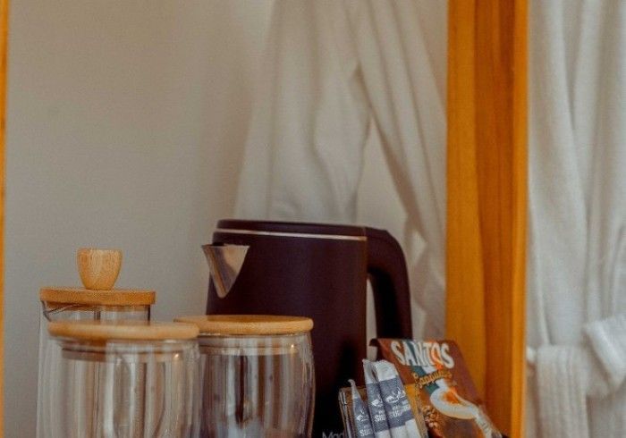 A table with a kettle and glasses on it.