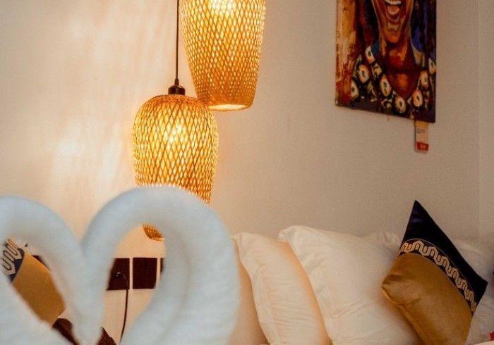 A bed with two swans on it and a painting on the wall