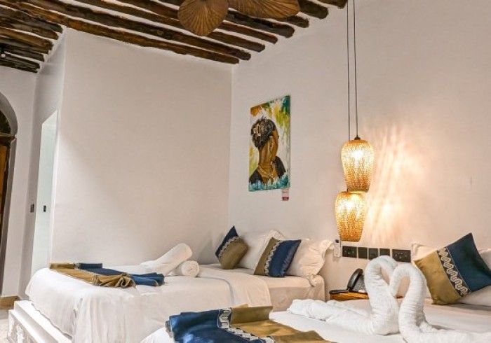 A hotel room with two beds and a painting on the wall.