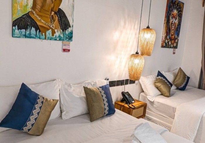 A hotel room with two beds and a painting on the wall