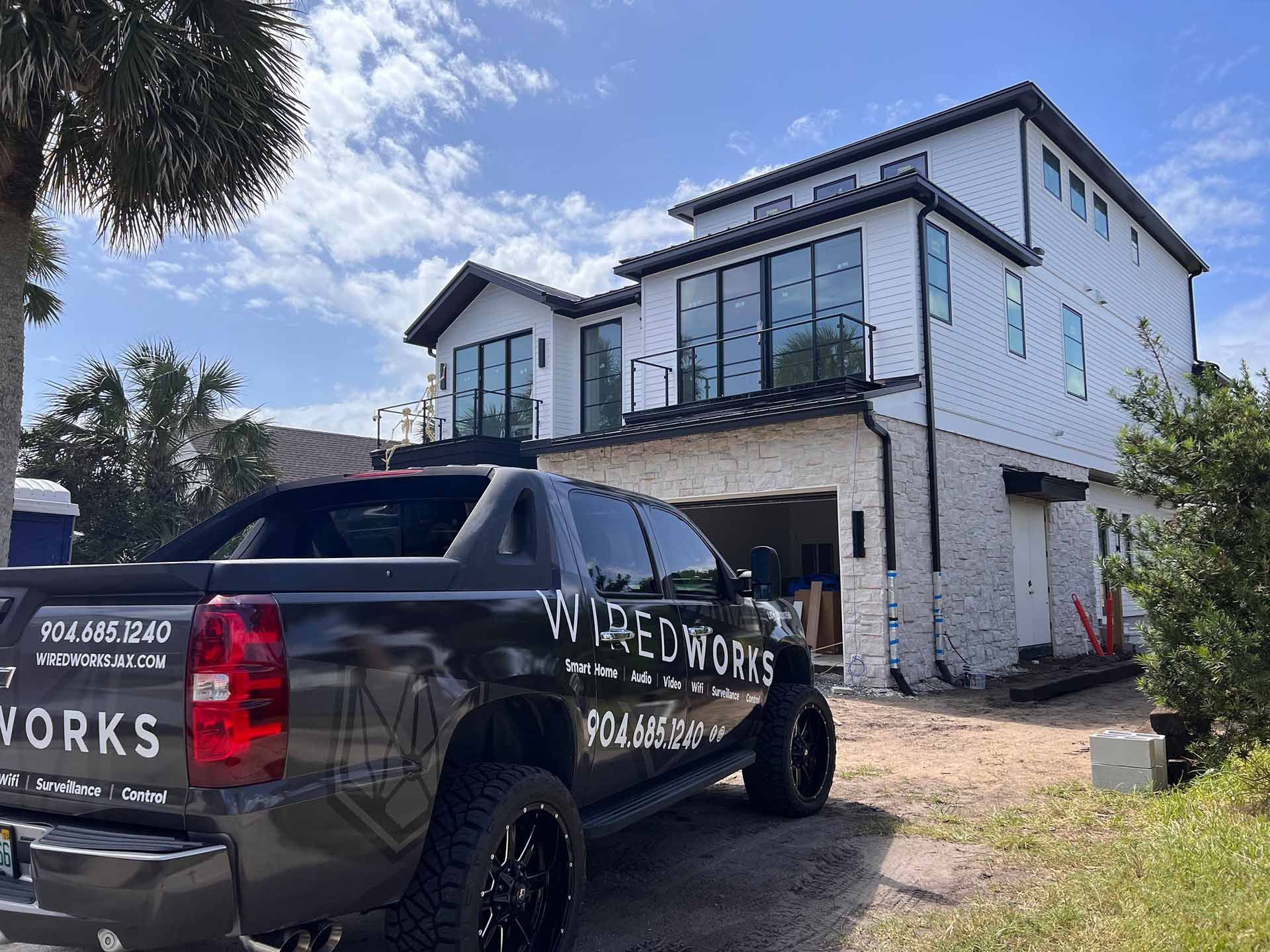 A Black Truck Is Parked In Front Of A Large White House — Ponte Vedra Beach, FL — Wired Works LLC