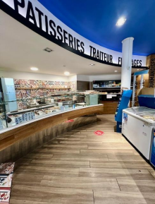 Intérieur d'une pâtisserie : parquet, vitrines vitrées, enseigne 