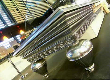 Table de billard métallique brillante avec pieds et garnitures décoratifs dans un cadre moderne.