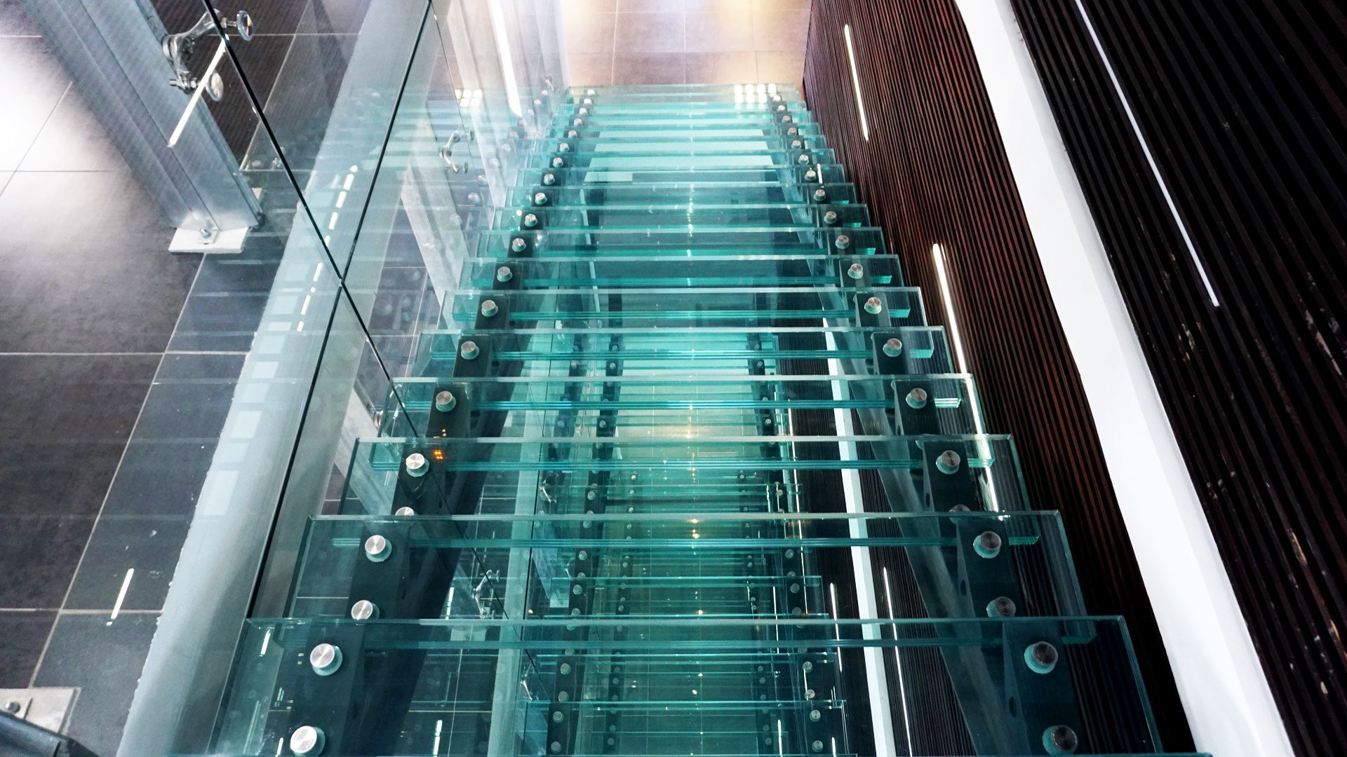 Escalier en verre dans un immeuble moderne. Marches claires avec supports métalliques.