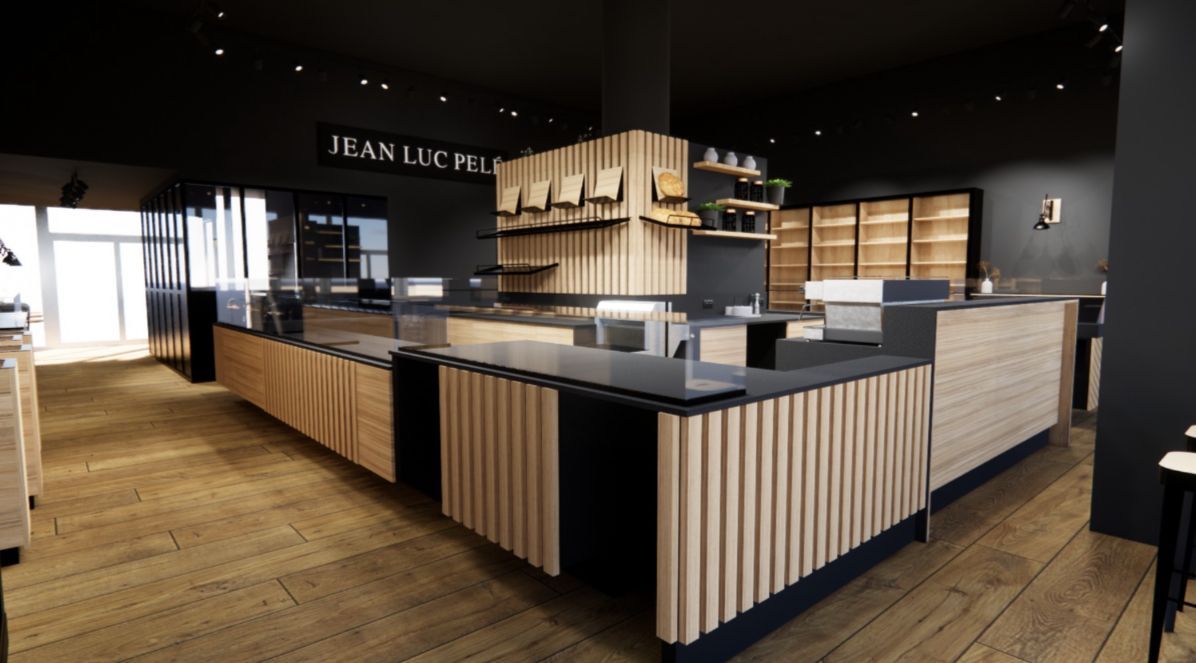 Intérieur de boulangerie avec comptoirs en bois, étagères et touches de noir. Parquet clair et murs sombres.