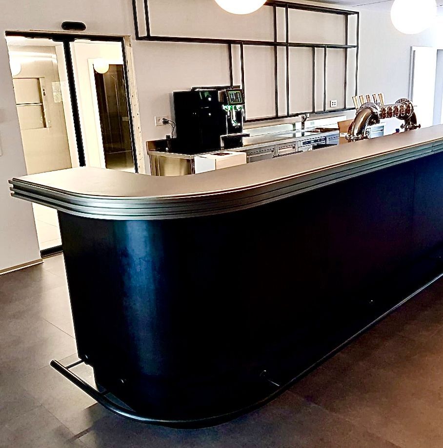 Bar rétro bleu foncé avec garniture en métal et machine à café, dans un cadre moderne.