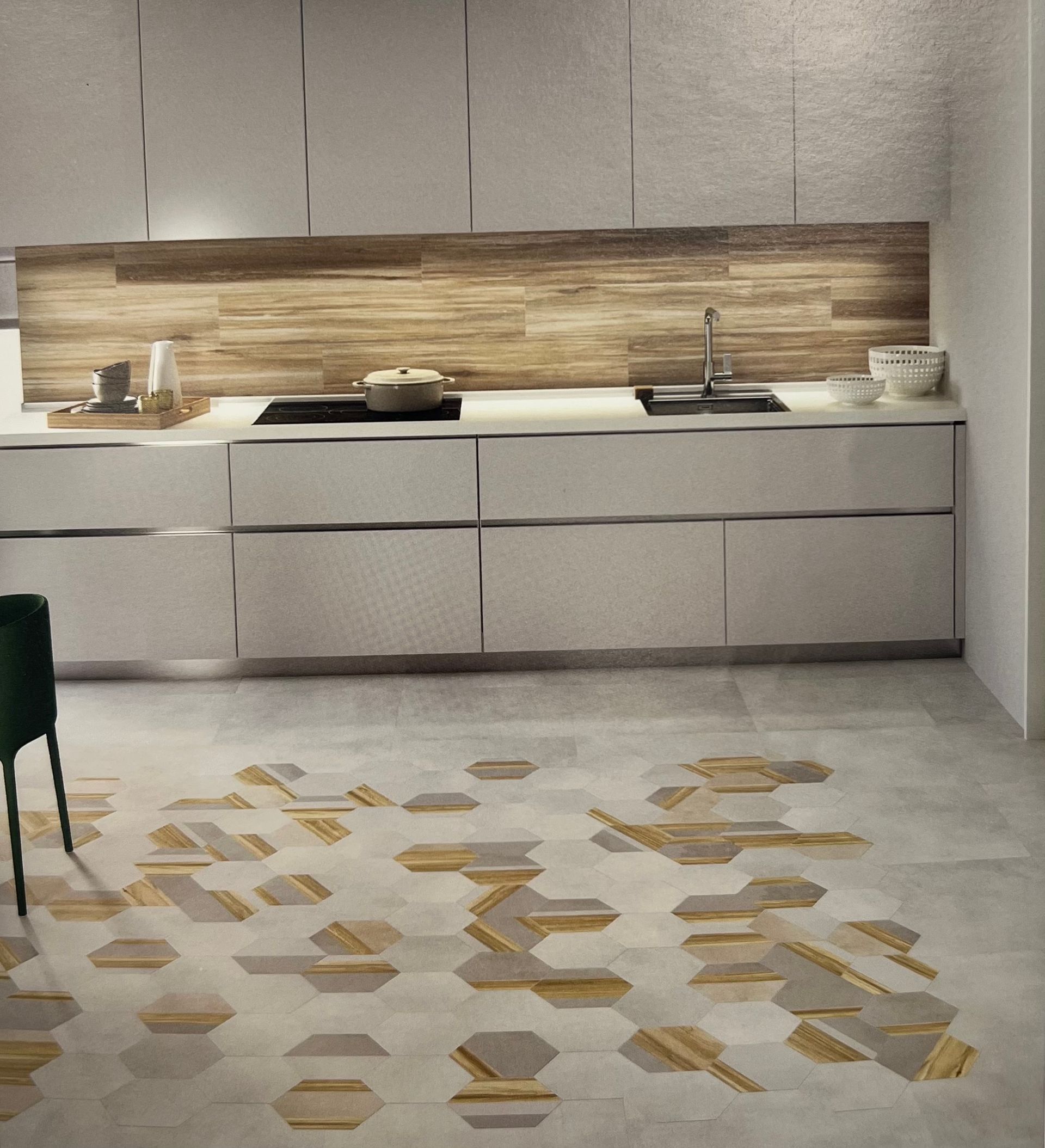 Cuisine moderne avec dosseret en bois, armoires blanches et carreaux de sol hexagonaux à motifs.