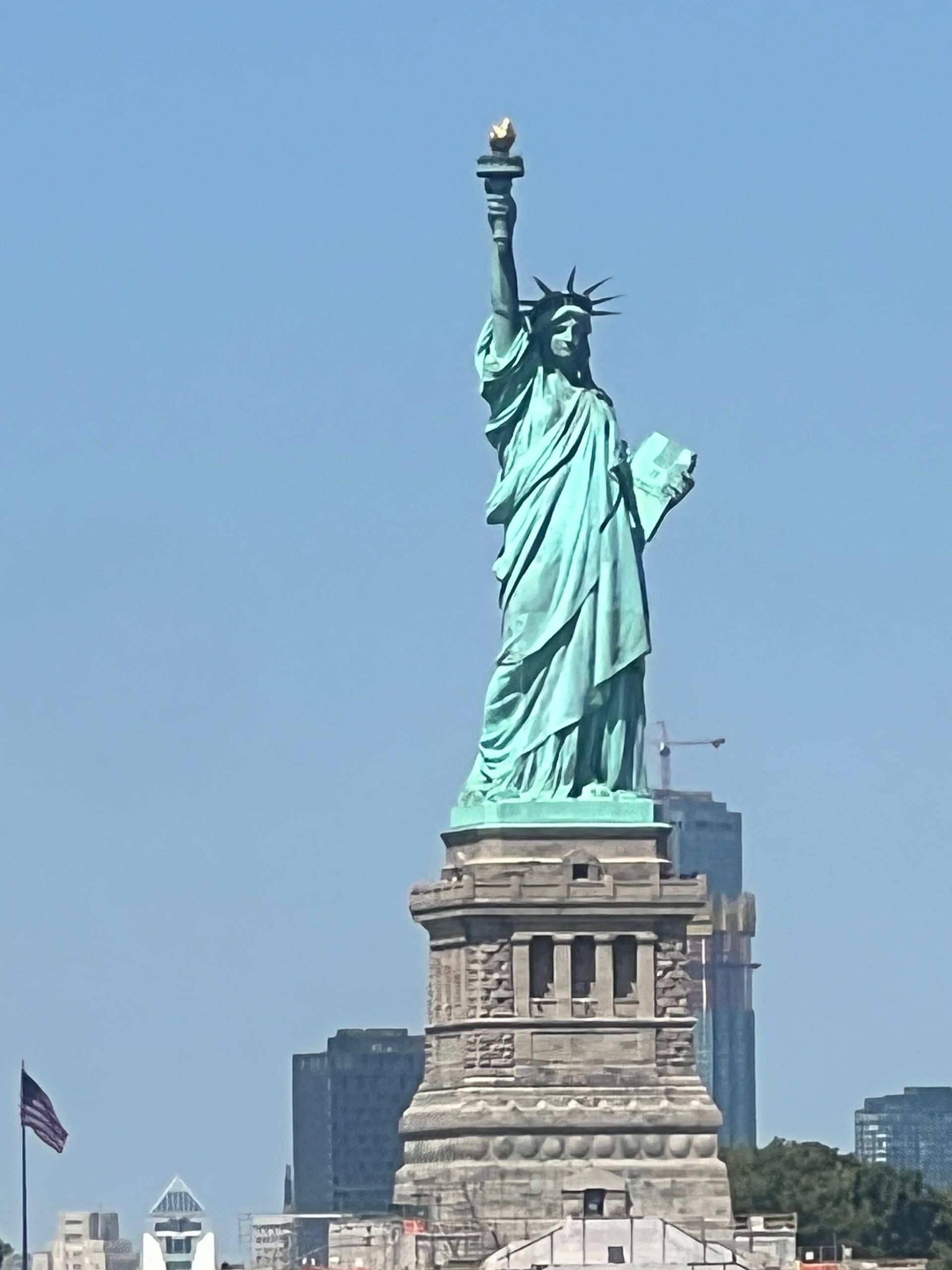 Statue de la Liberté, New York, un grand monument turquoise contre un ciel bleu clair.
