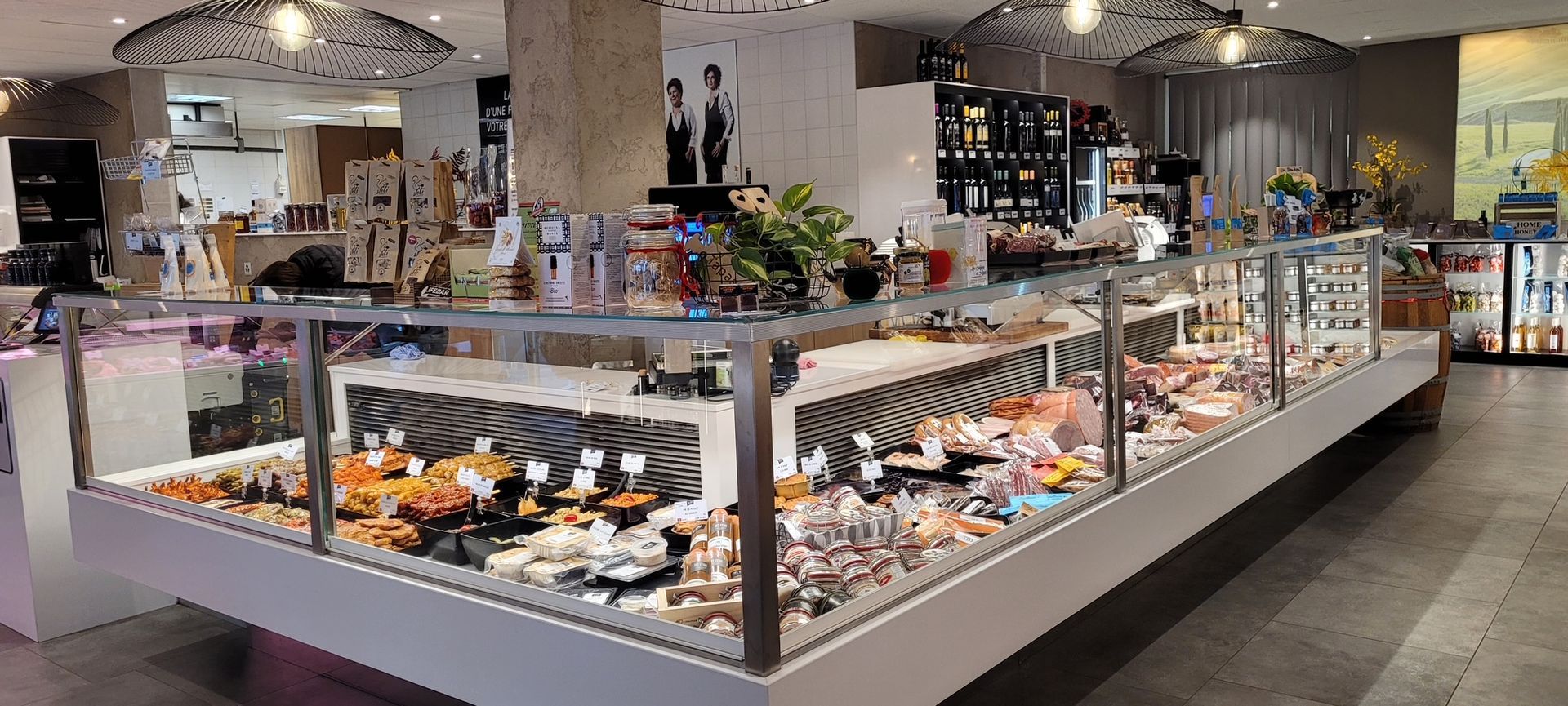 Une vitrine de charcuterie remplie de diverses viandes et aliments préparés dans un magasin.