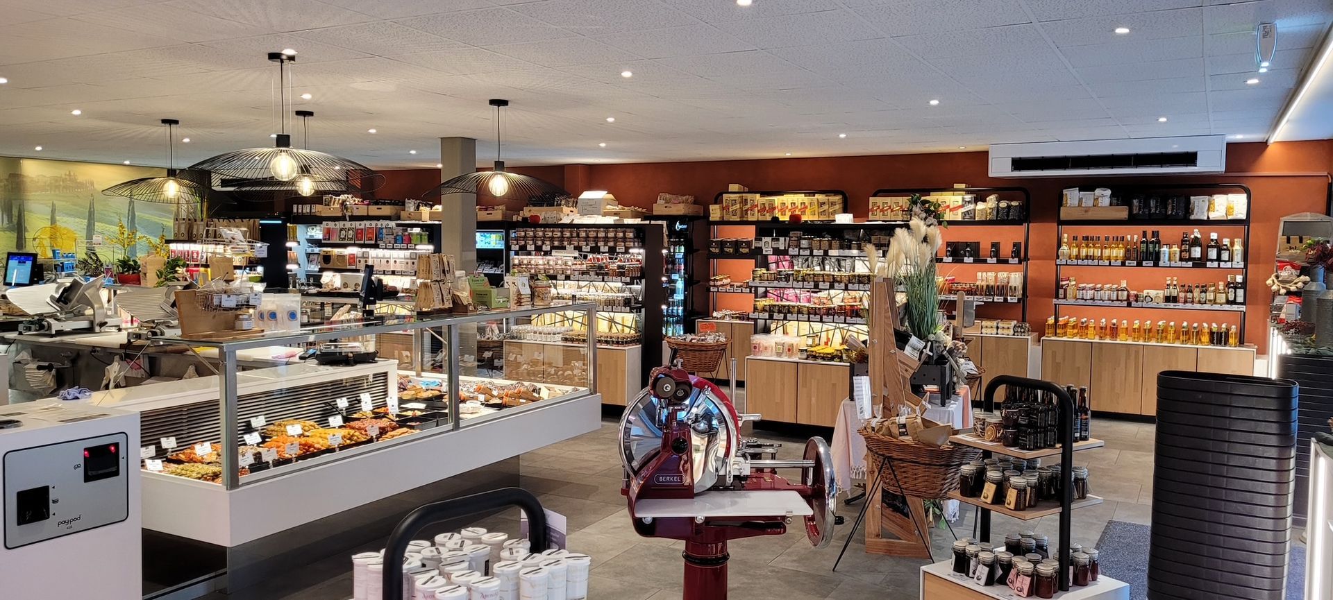 Intérieur d'une boutique gastronomique avec divers aliments et objets de décoration exposés.