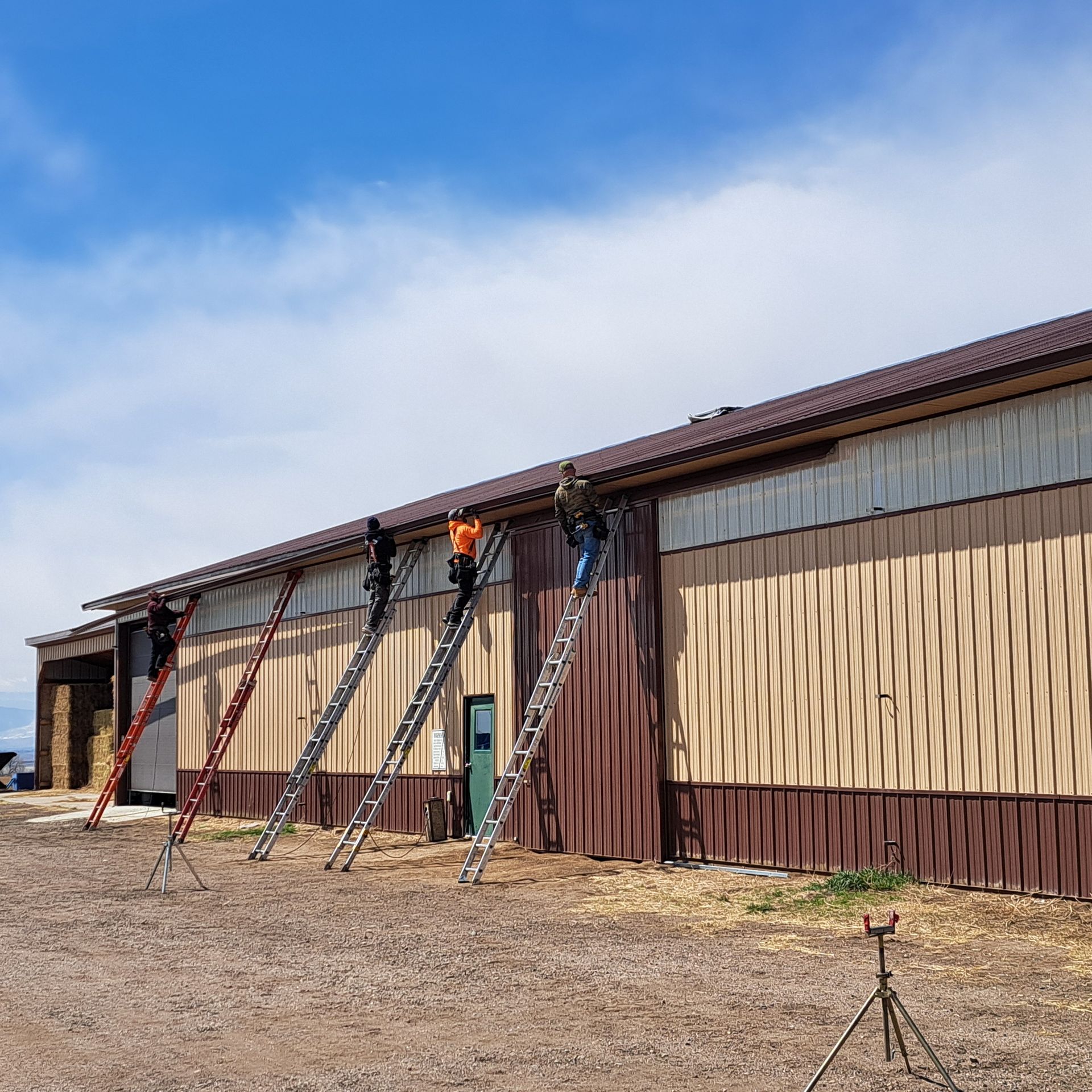 A row of ladders are lined up in front of a building.