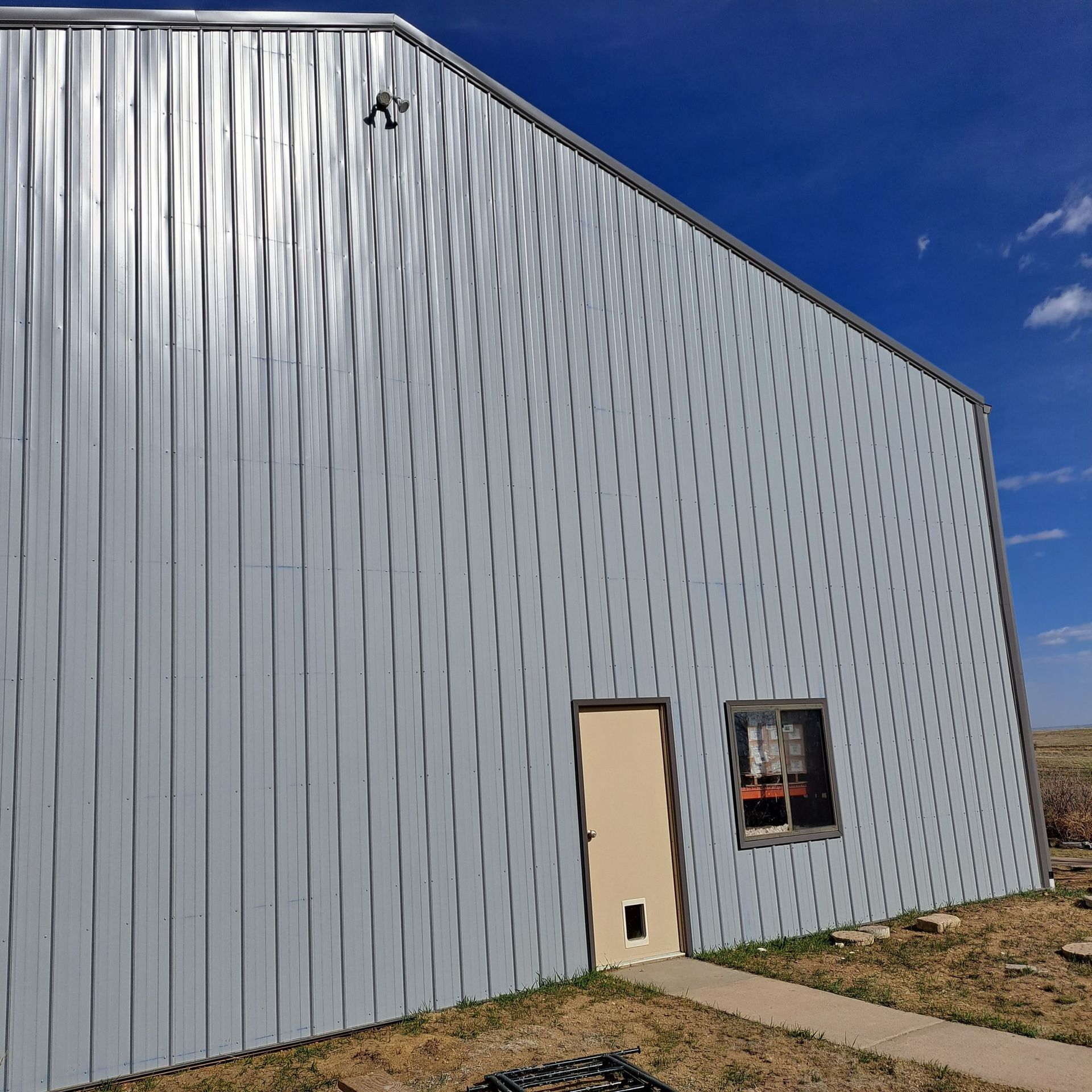 A large white building with a door and two windows