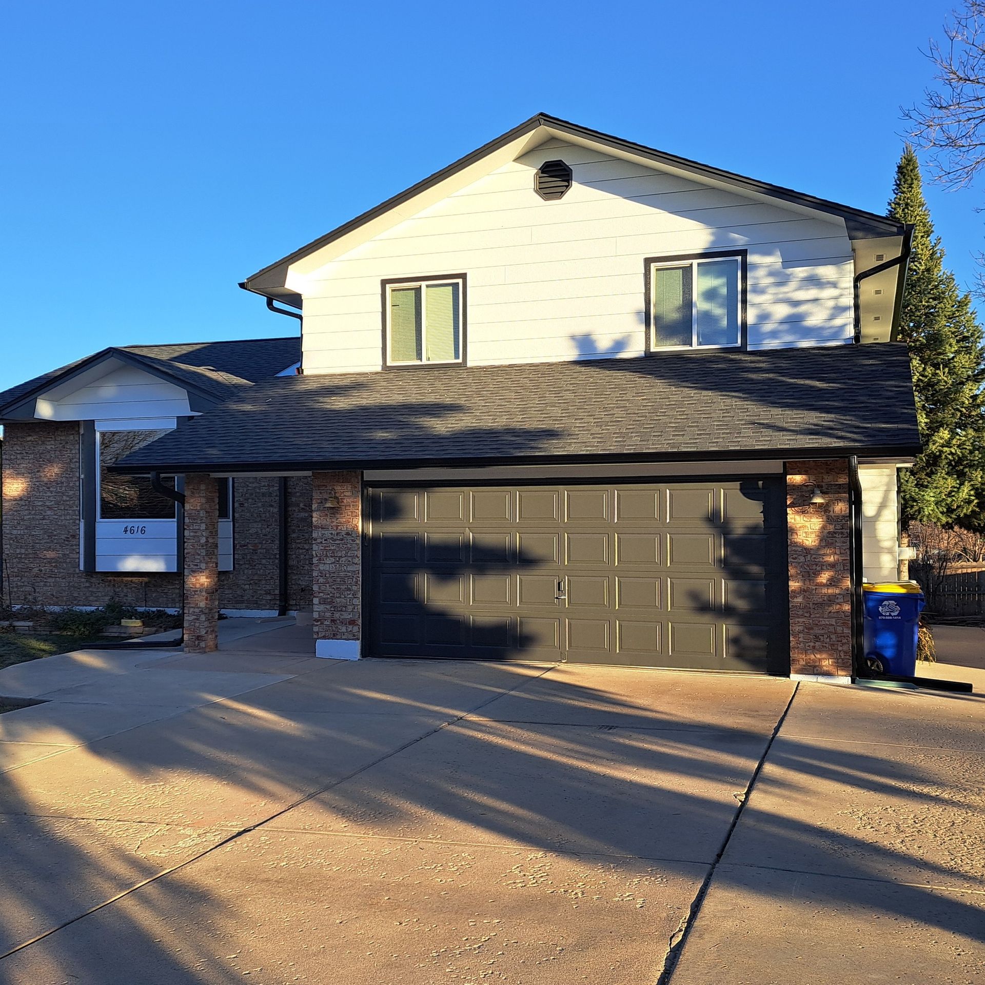 A large white house with a black garage door