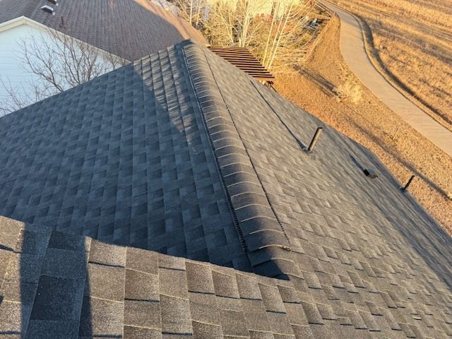 A roof with a lot of shingles on it and a road in the background.