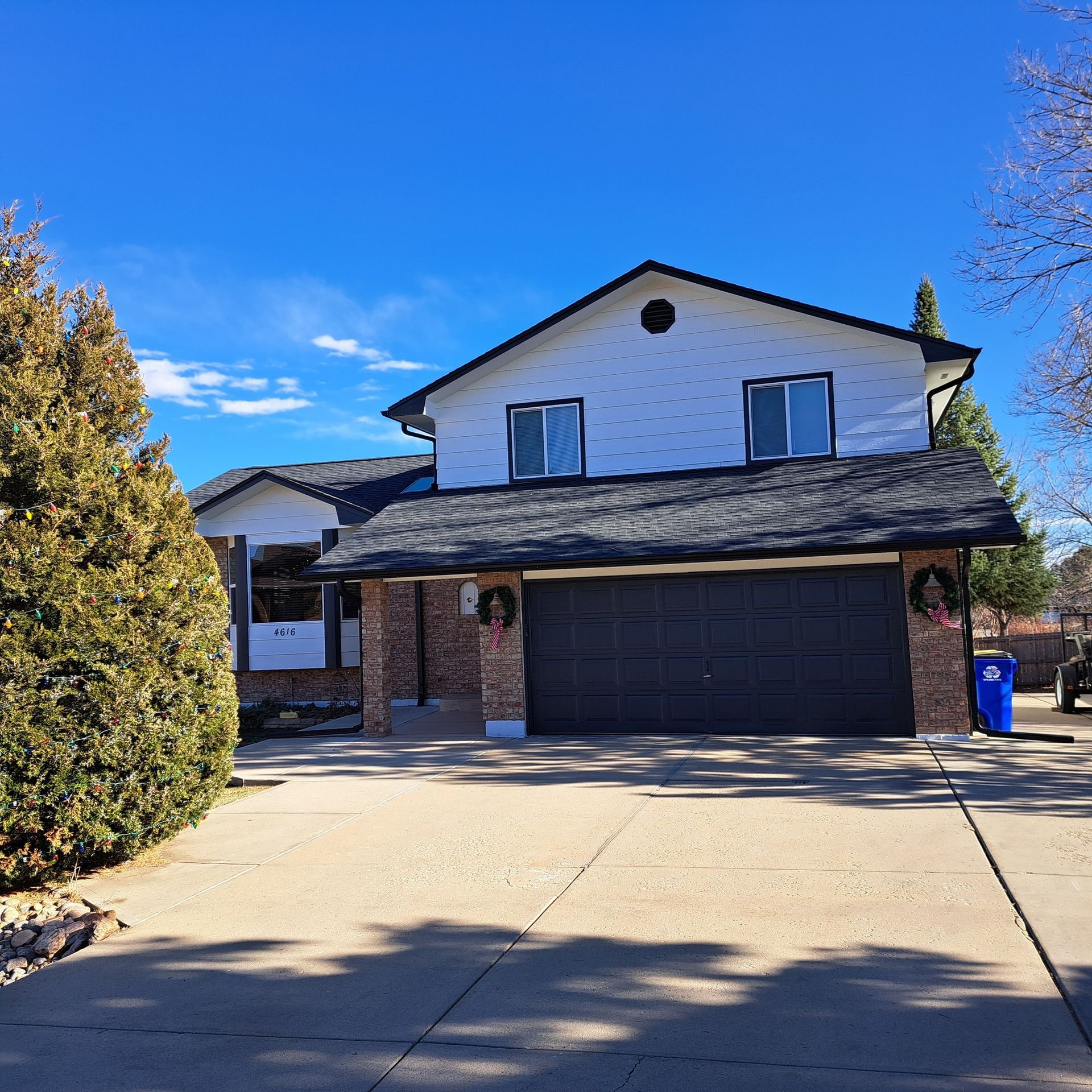 A large white house with a black garage door