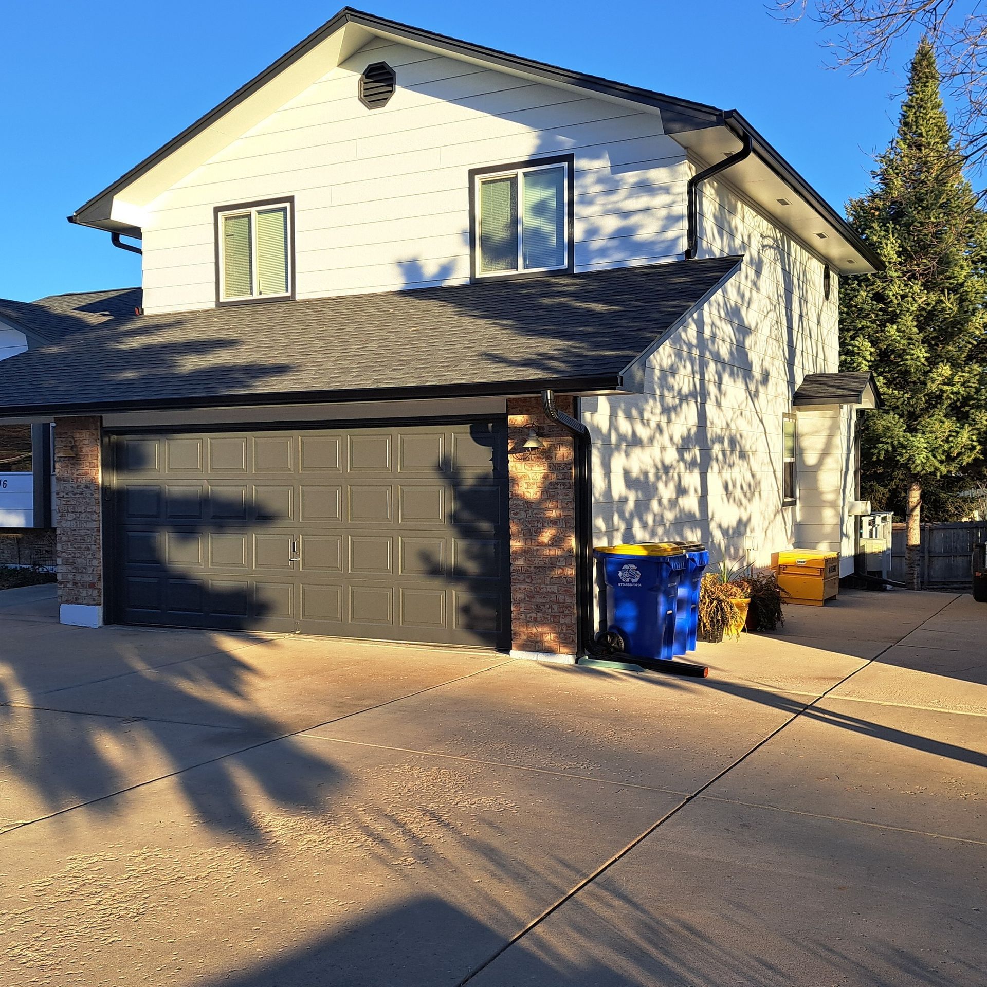 A large white house with a black garage door