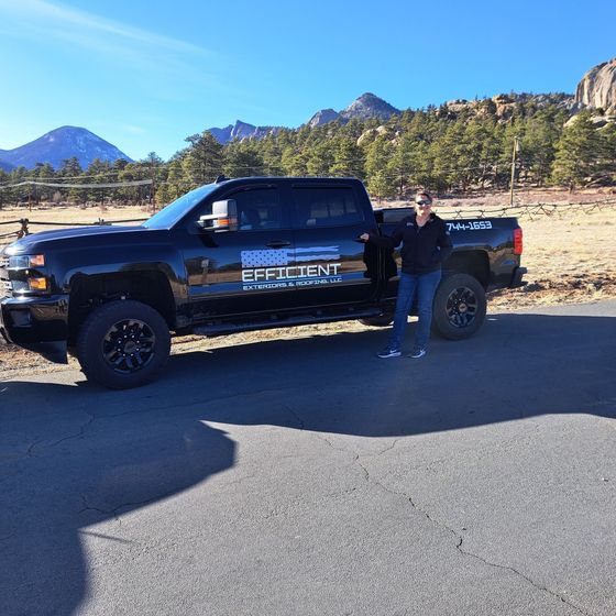 A man stands in front of a truck that says efficient