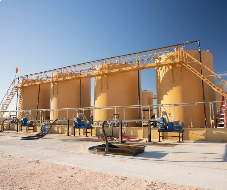 A row of large yellow tanks with stairs leading up to them