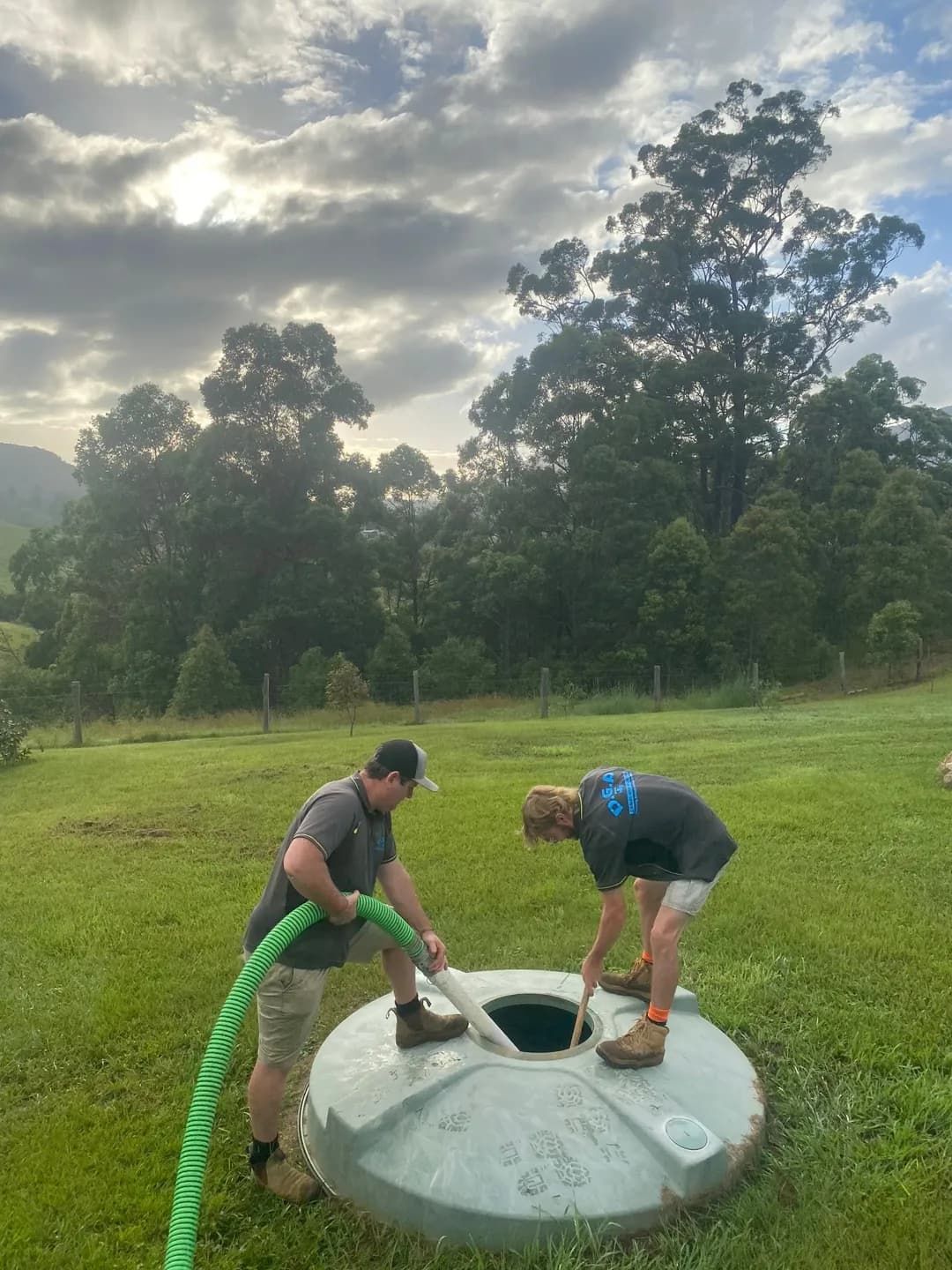 Two Men Are Working on a Septic Tank in a Field — Tweed Valley Septics & Liquid Waste Management in South Murwillumbah, NSW