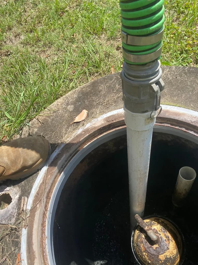 Manhole Cover With a Green Hose Coming Out of It — Tweed Valley Septics & Liquid Waste Management in South Murwillumbah, NSW