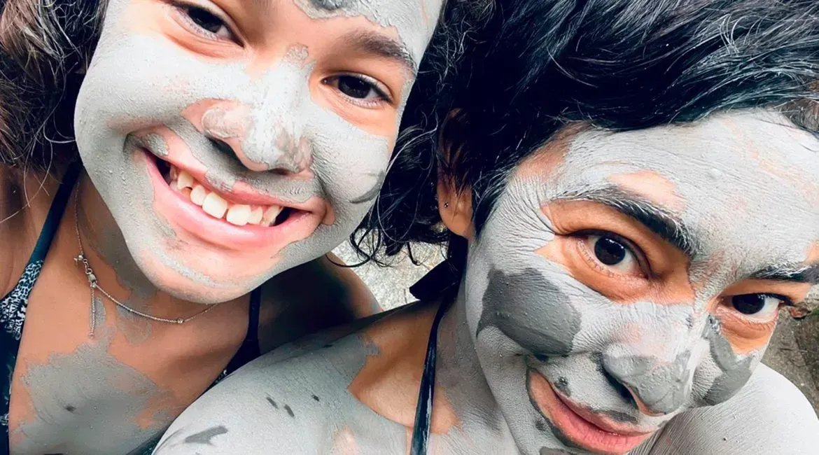 A boy and a girl with mud on their faces.