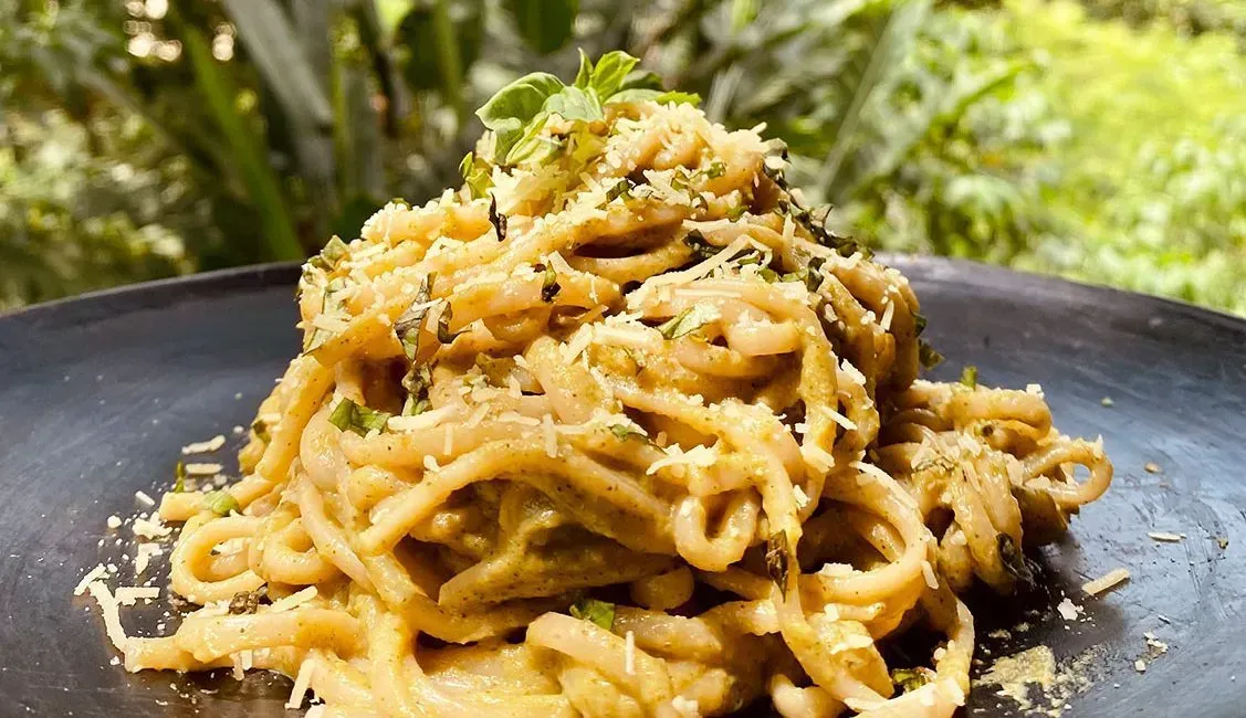 A close up of a plate of pasta on a table.