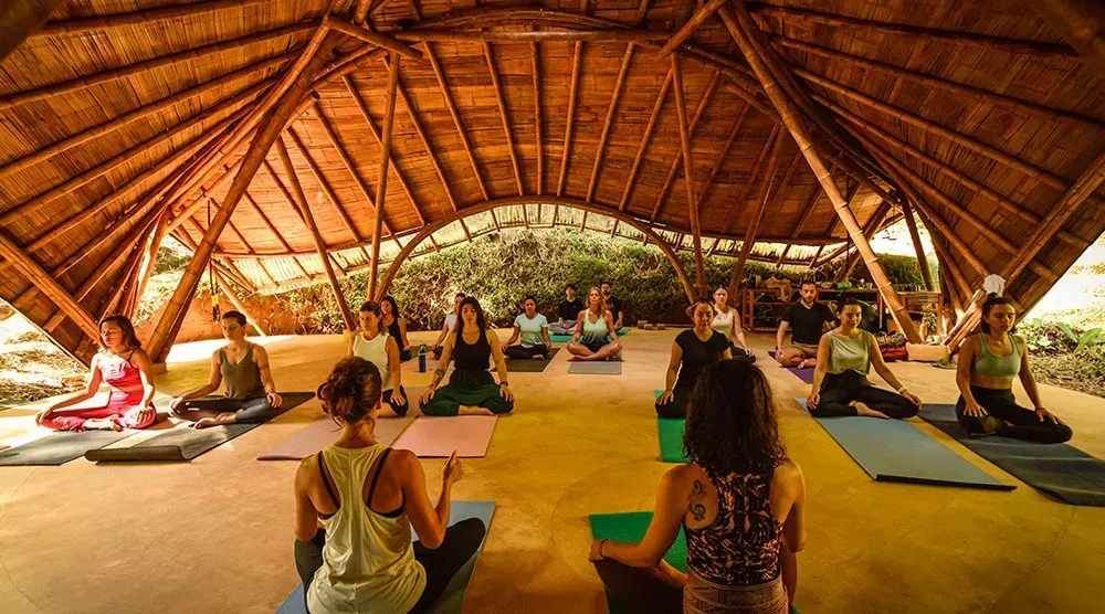 A group of people are doing yoga in a wooden building.