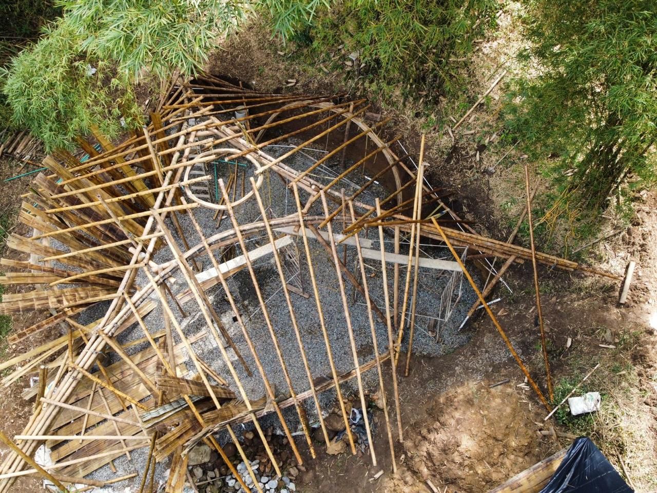 An aerial view of a wooden structure being built in the woods.