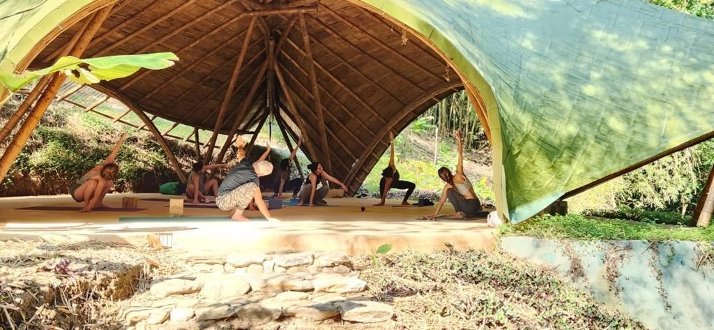 A group of people are doing yoga in a tent.