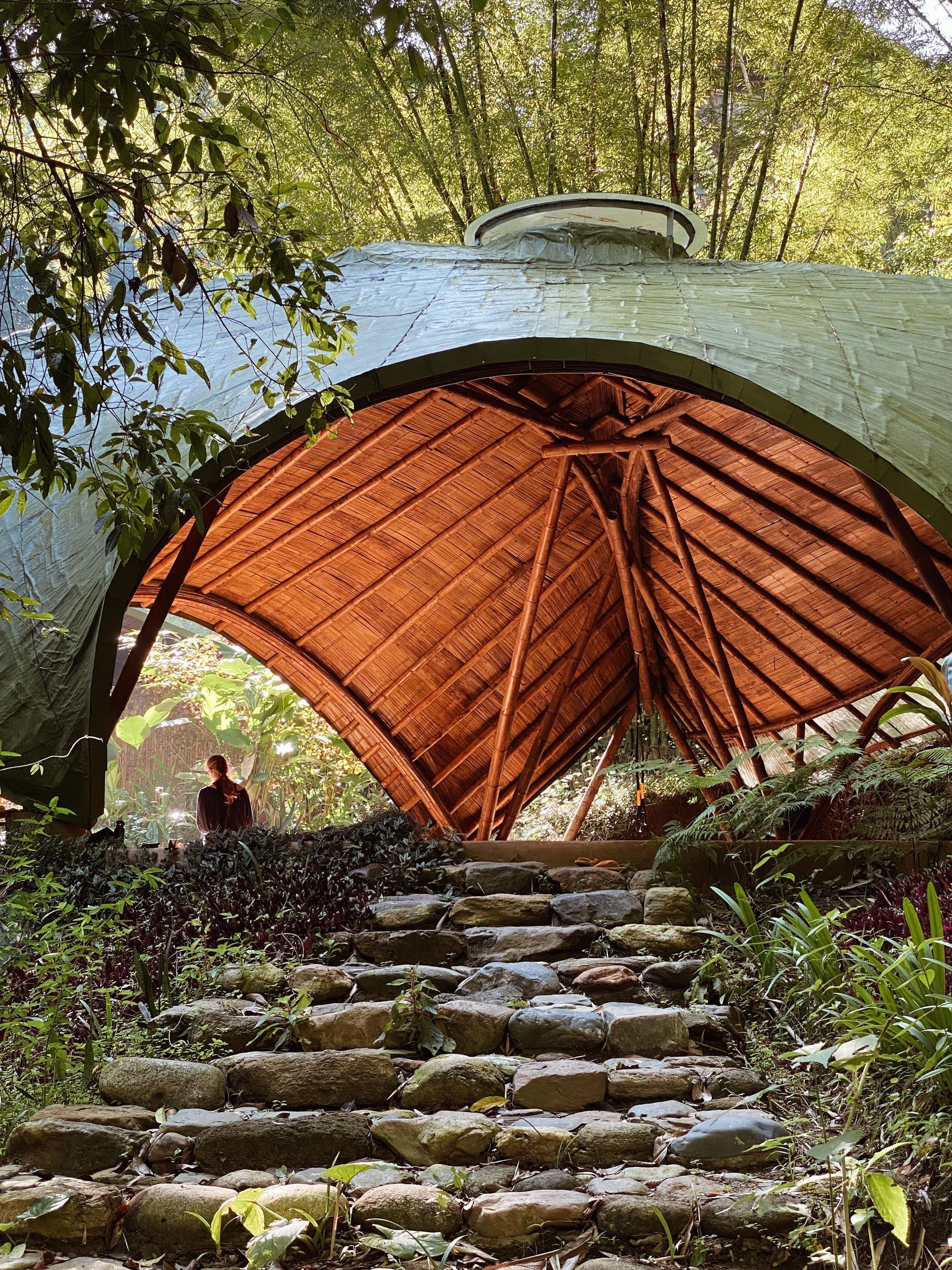 A stone staircase leading up to a wooden structure in the woods.