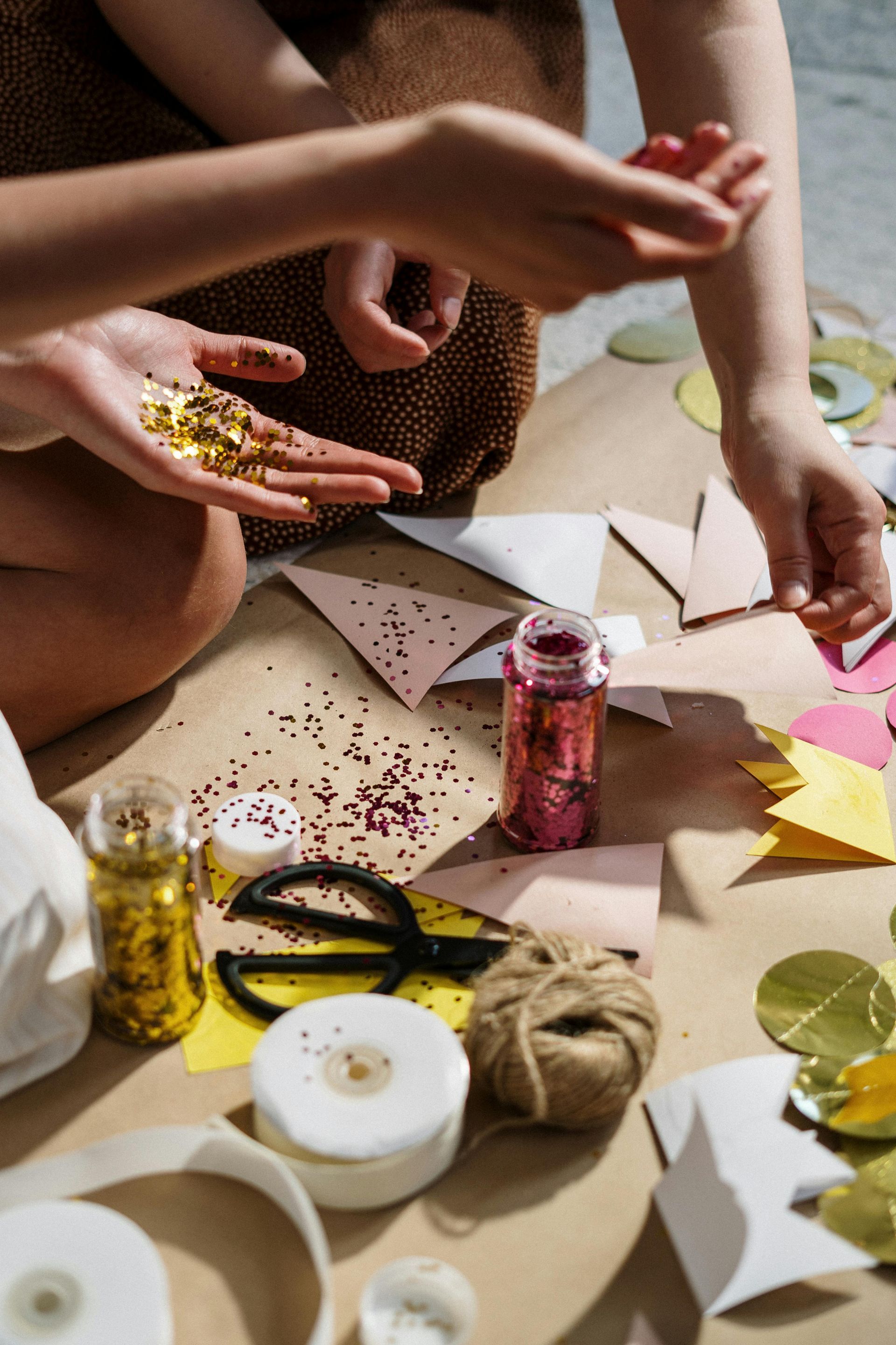 A group of people are sitting on the floor making crafts.