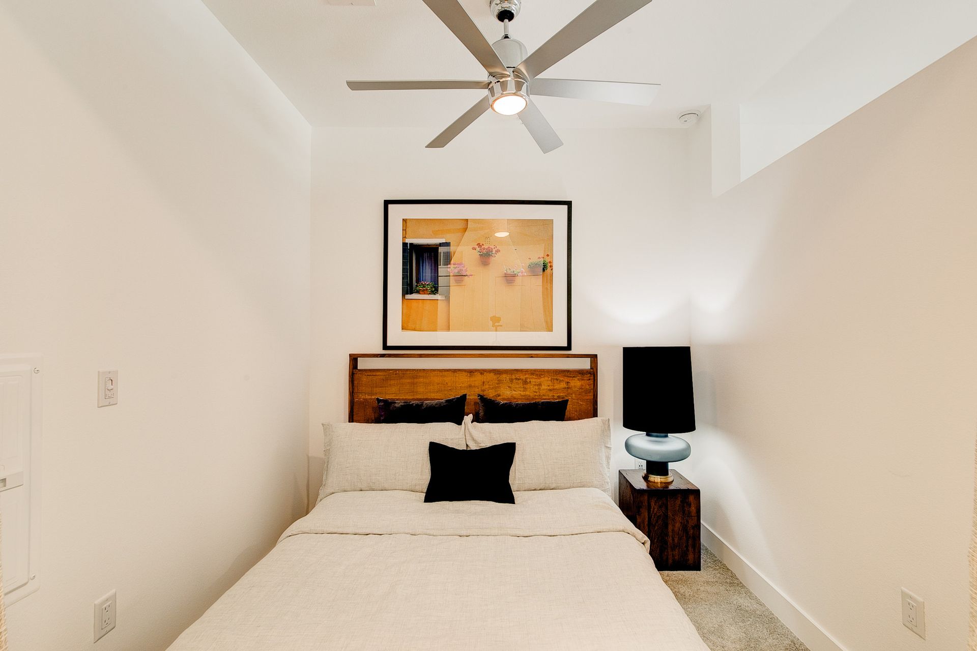 A bedroom with a bed and a ceiling fan
