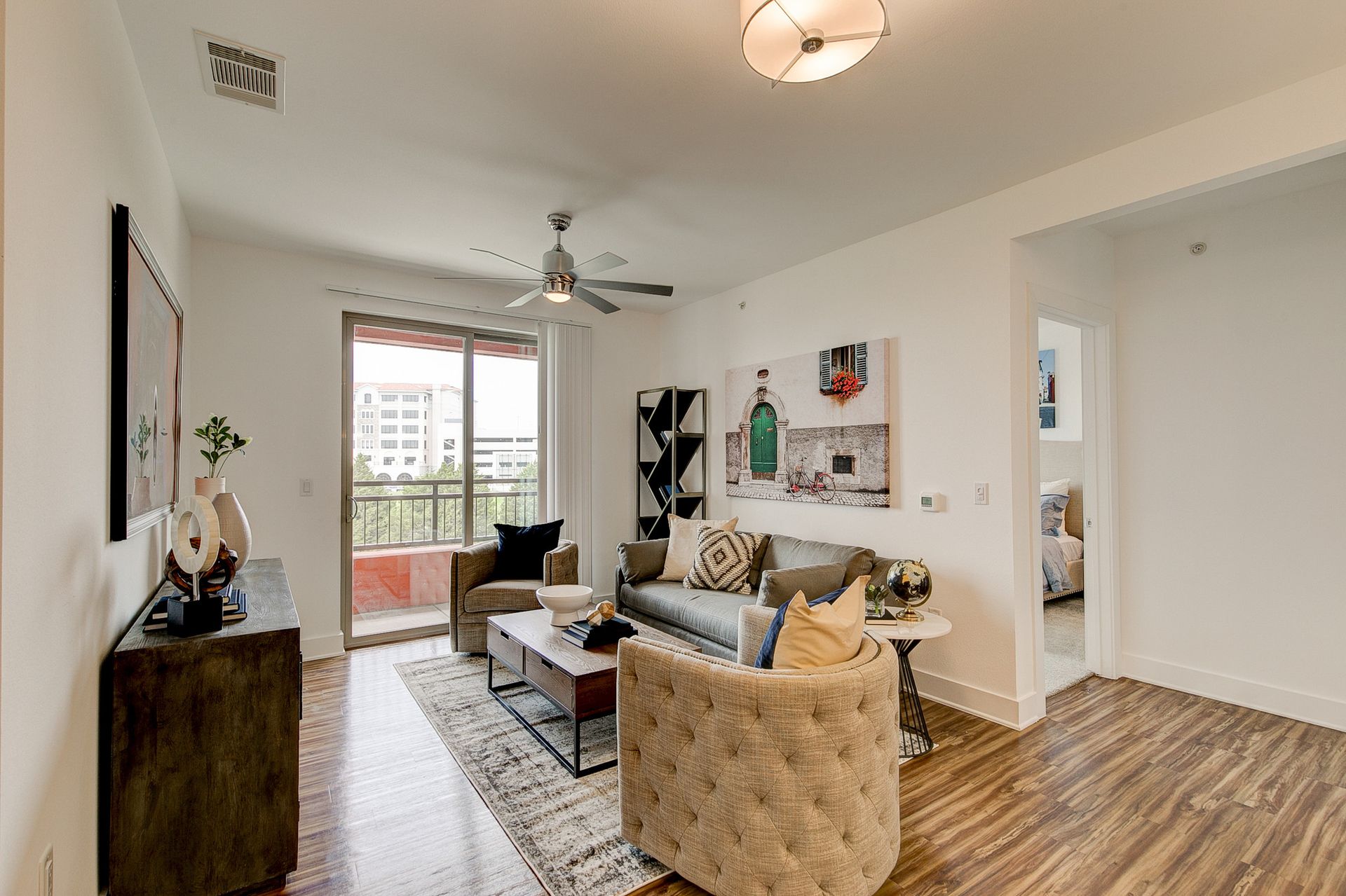 A living room with a couch , chairs , and a ceiling fan.
