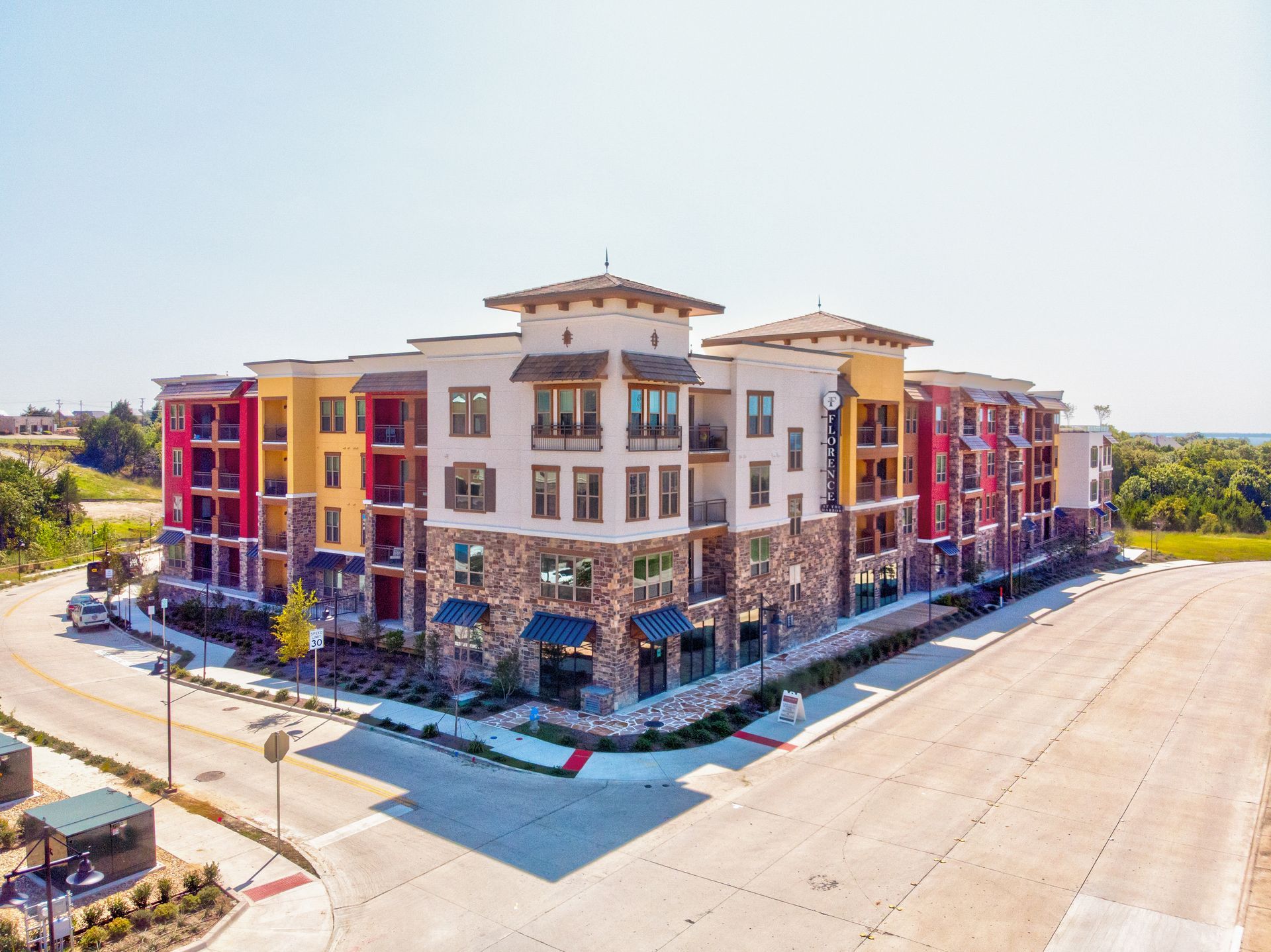 An aerial view of a large apartment building next to a road.