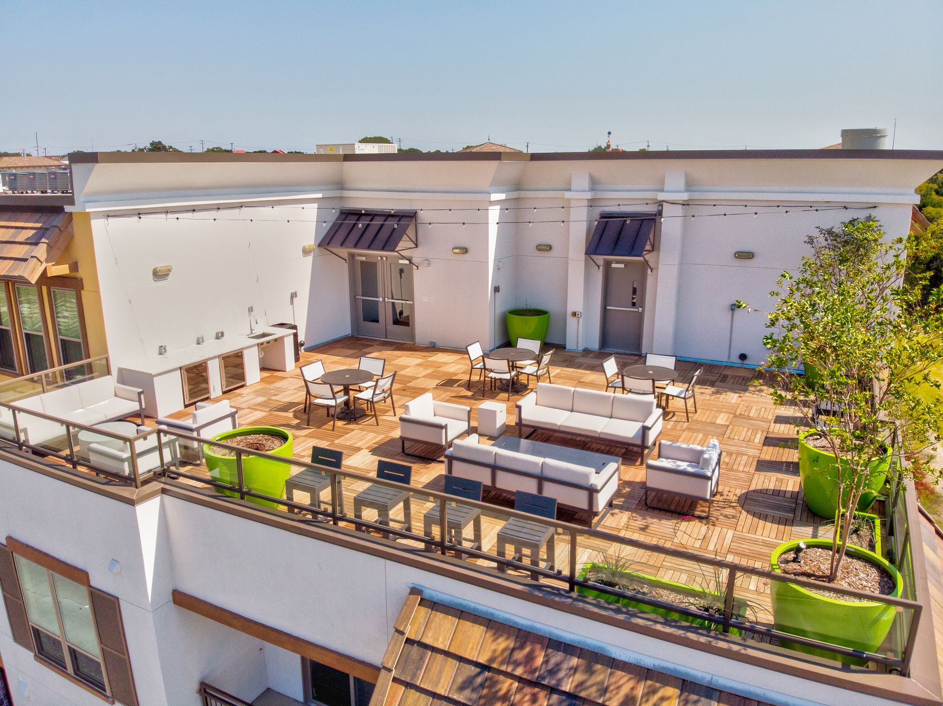 An aerial view of a rooftop terrace with furniture and tables.