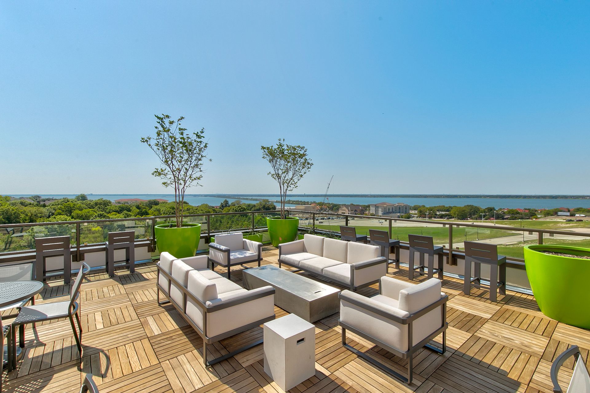 A patio with a lot of furniture and a view of the ocean.
