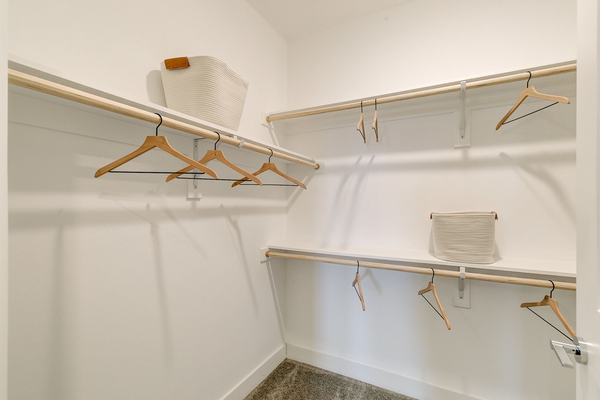 A walk in closet with lots of shelves and hangers.