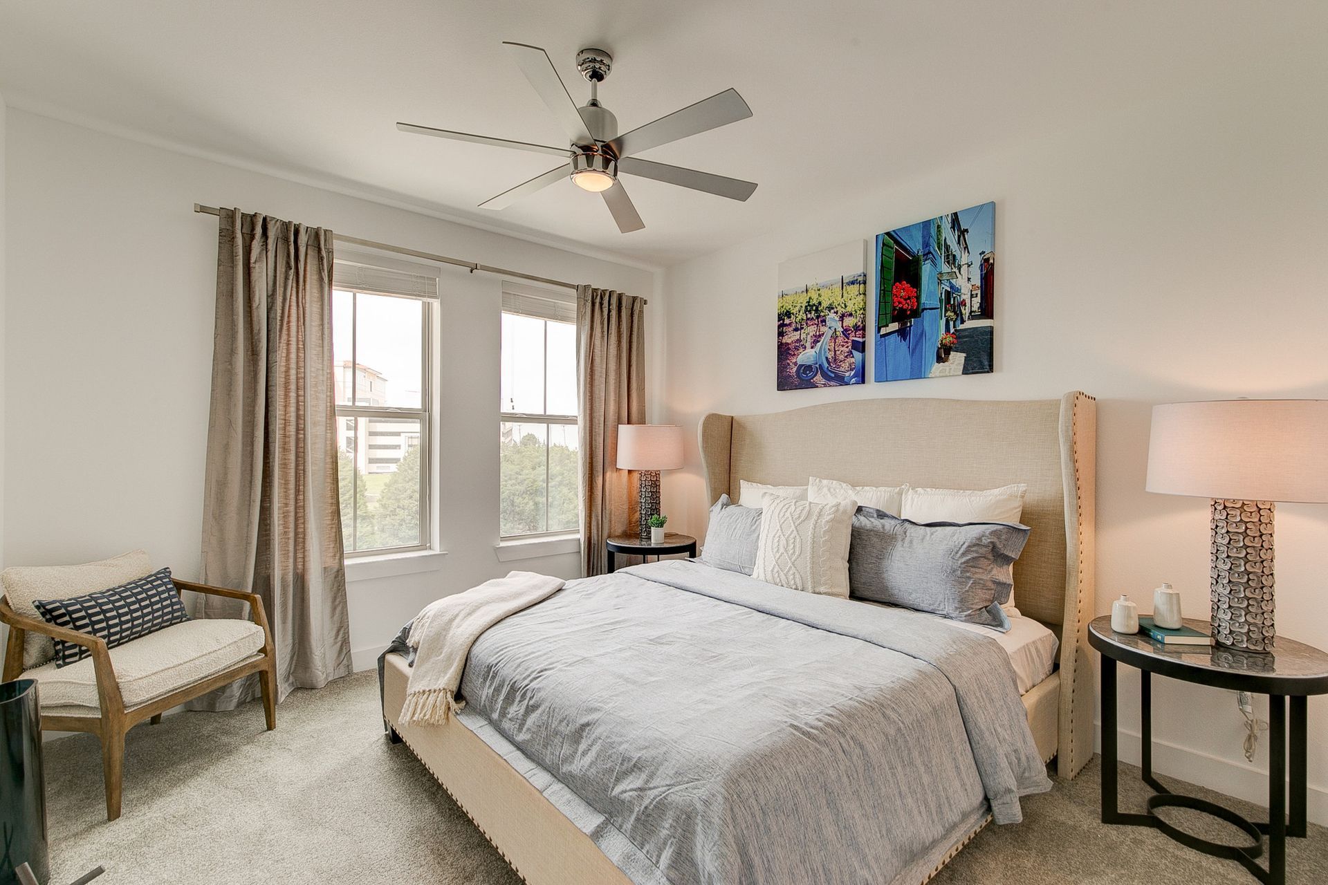 A bedroom with a large bed and a ceiling fan.