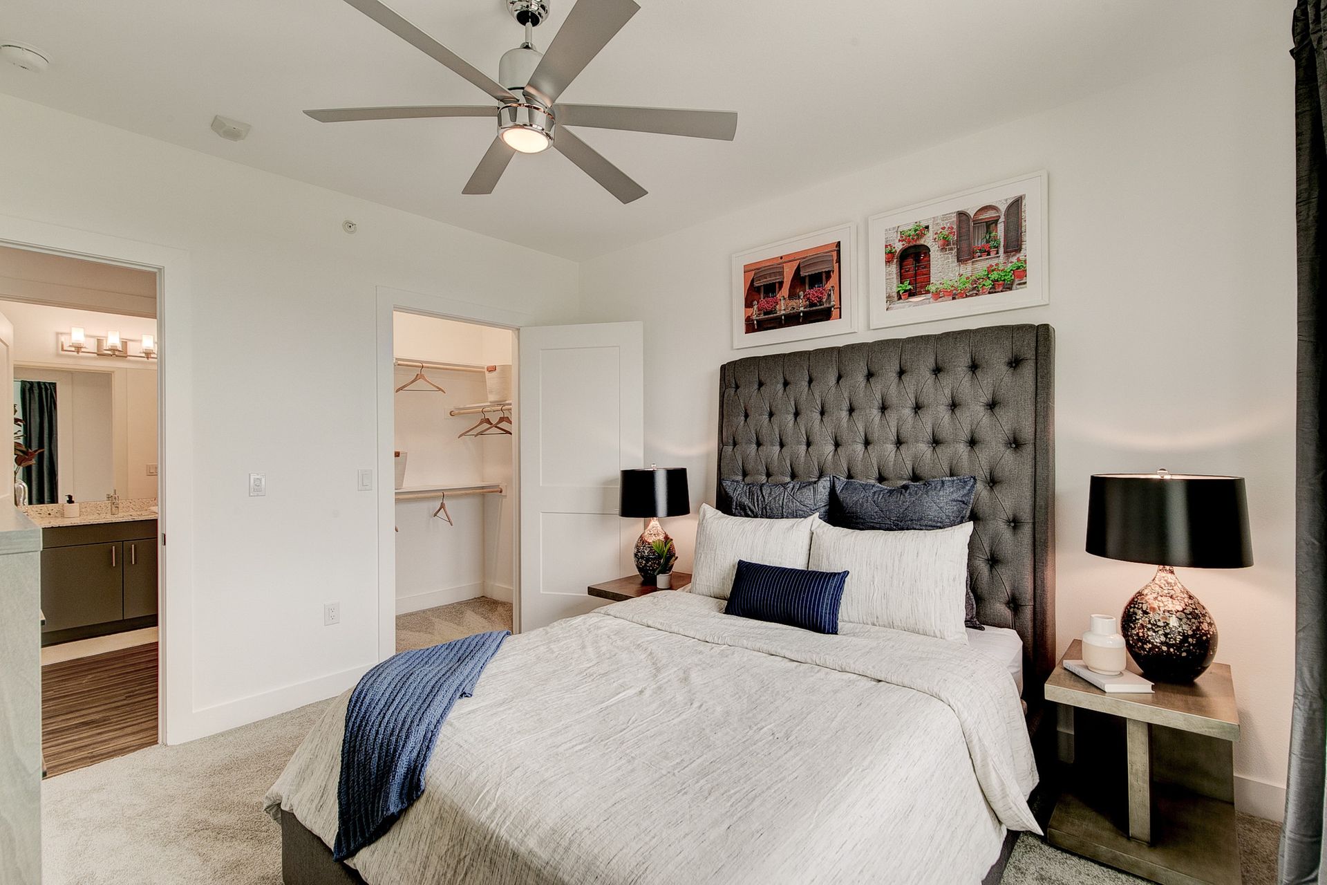 A bedroom with a large bed and a ceiling fan.