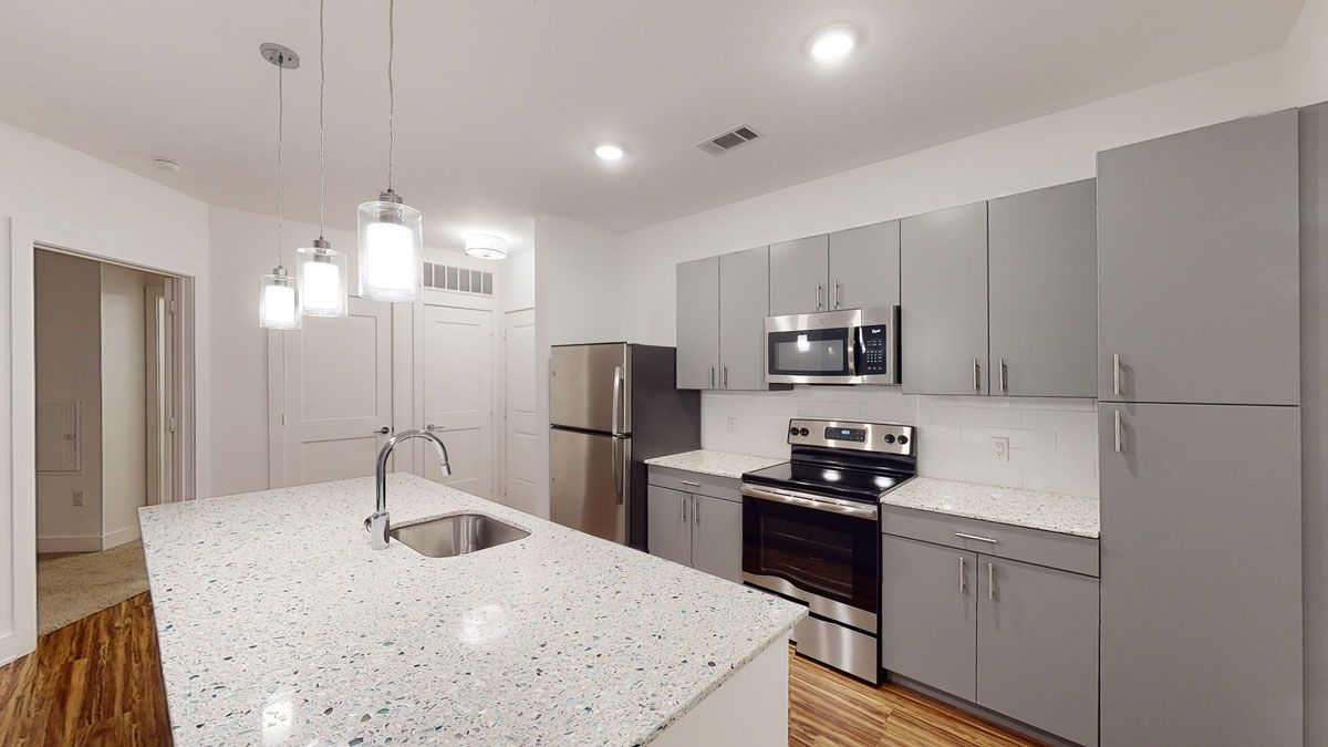 A kitchen with stainless steel appliances and granite counter tops.