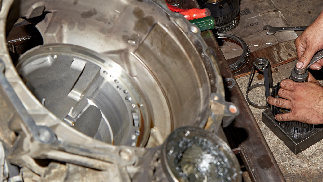 A person is working on a machine with a wrench.