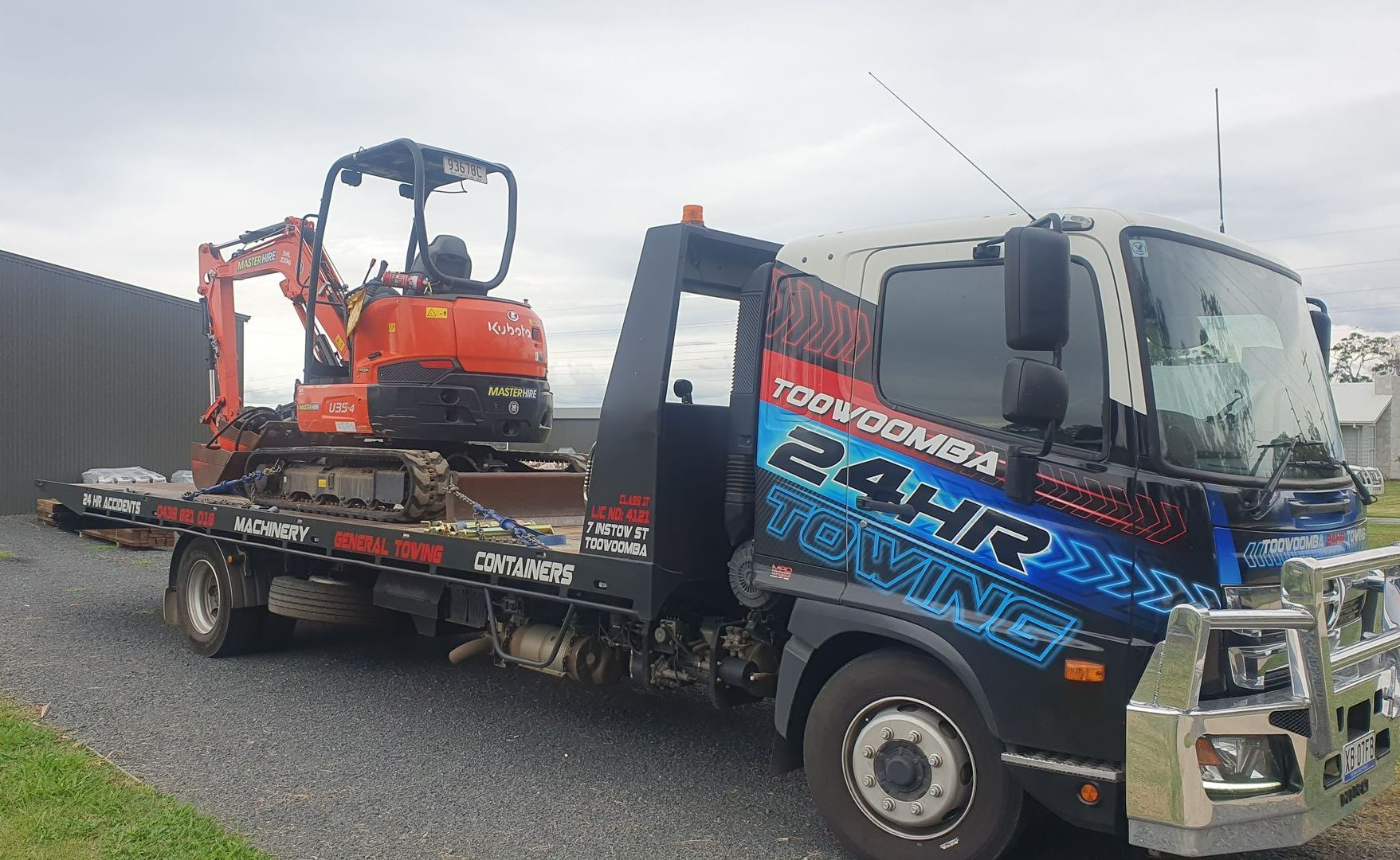 A Tow Truck With a Small Excavator on The Back of it — Toowoomba 24hr Towing In Toowoomba QLD