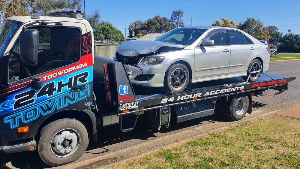Wrecked Car After An Accident On A Tow Truck Transported On A Highway — Toowoomba 24hr Towing In Toowoomba QLD
