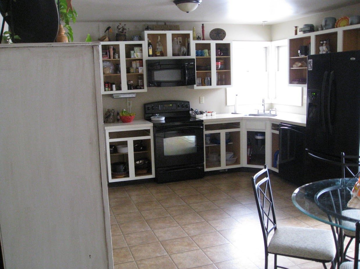 A kitchen with black appliances and white cabinets