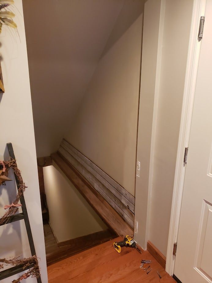 A staircase with a wooden railing is being built in a house.