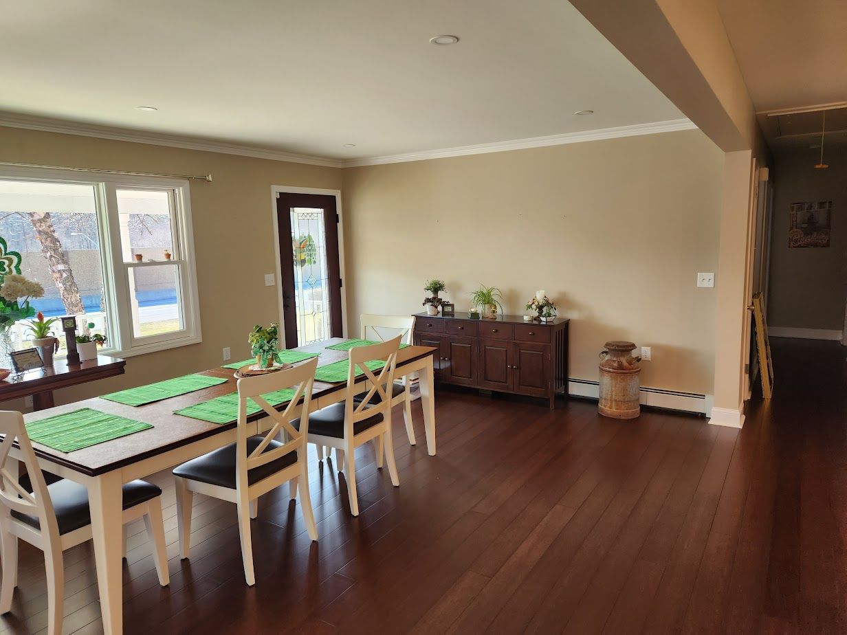 A large dining room with a long table and chairs.