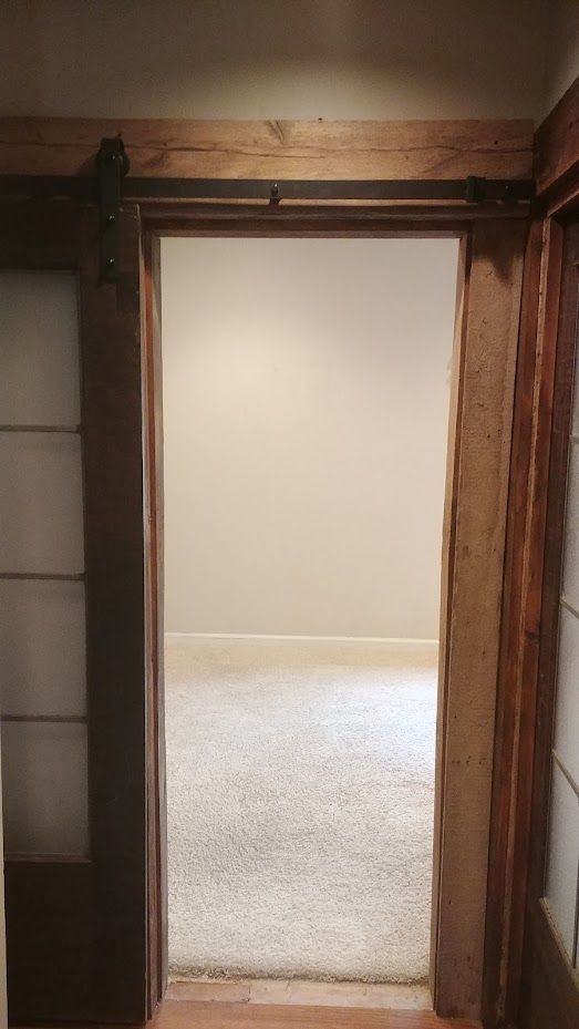 A doorway leading into an empty room with a carpeted floor.